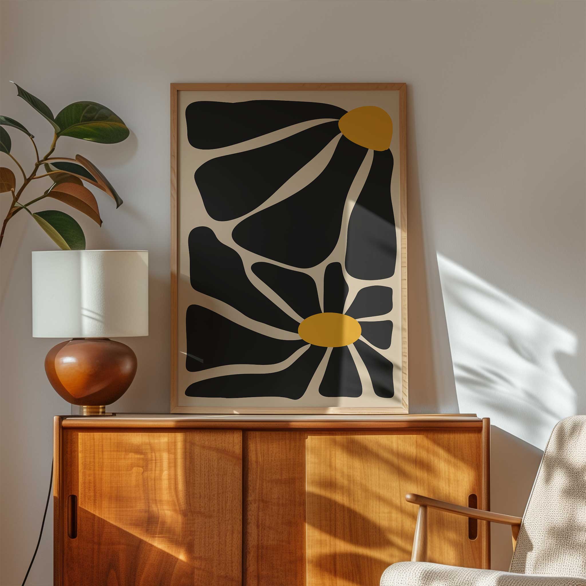 A bold, contemporary abstract print of two flowers with oversized black petals and vivid golden centers.