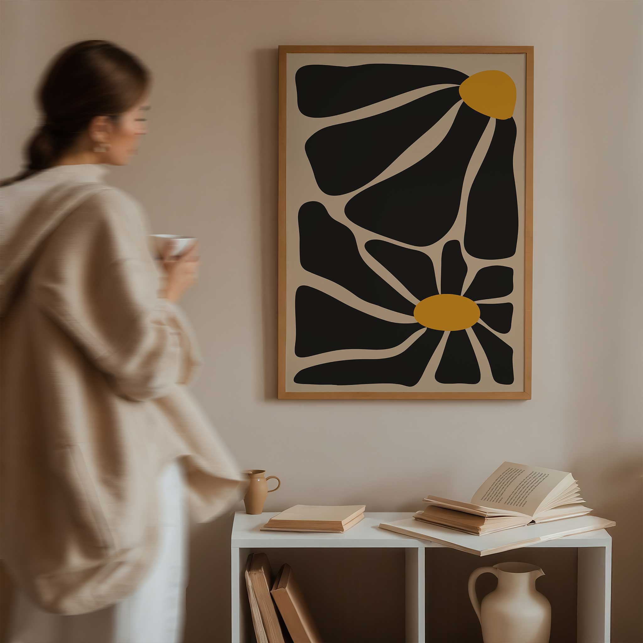 A bold, contemporary abstract print of two flowers with oversized black petals and vivid golden centers.