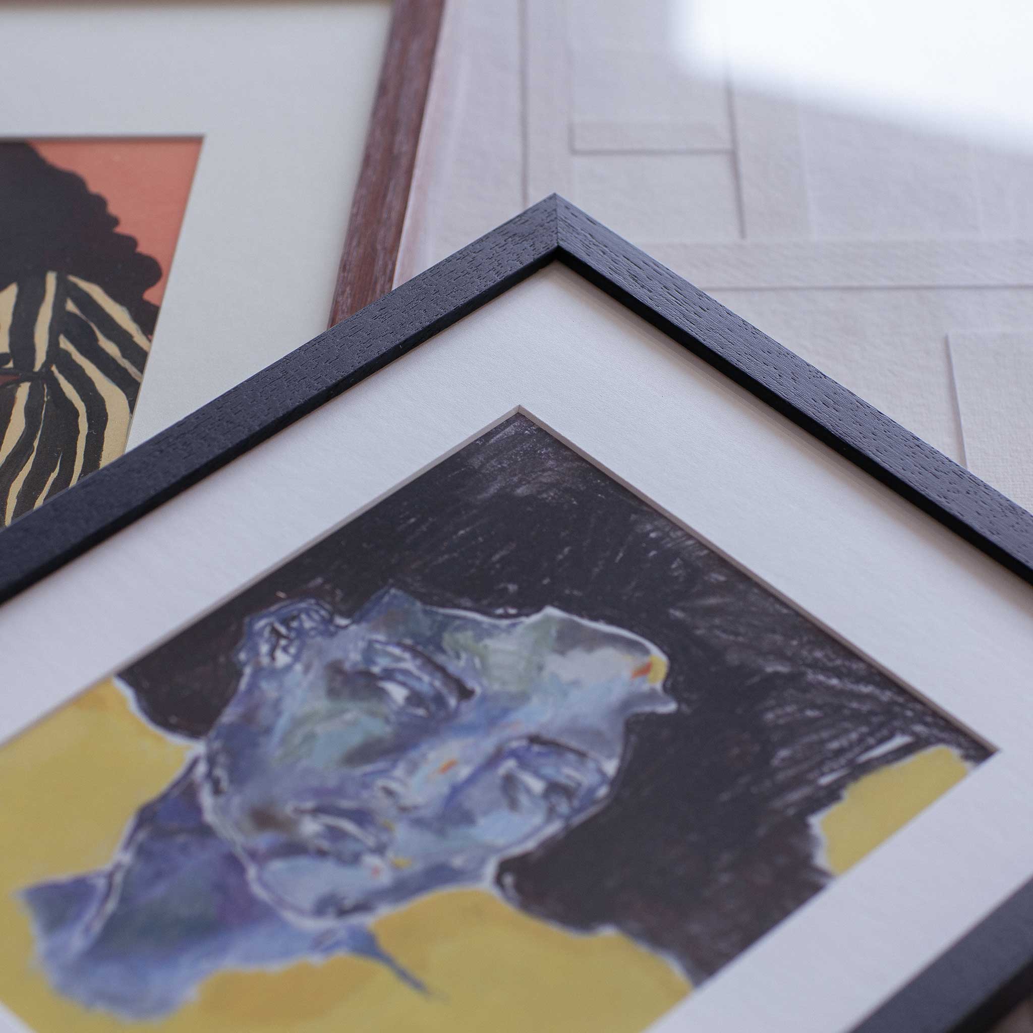 a close-up of a framed artwork depicting a stylized face with a blue and black color scheme.