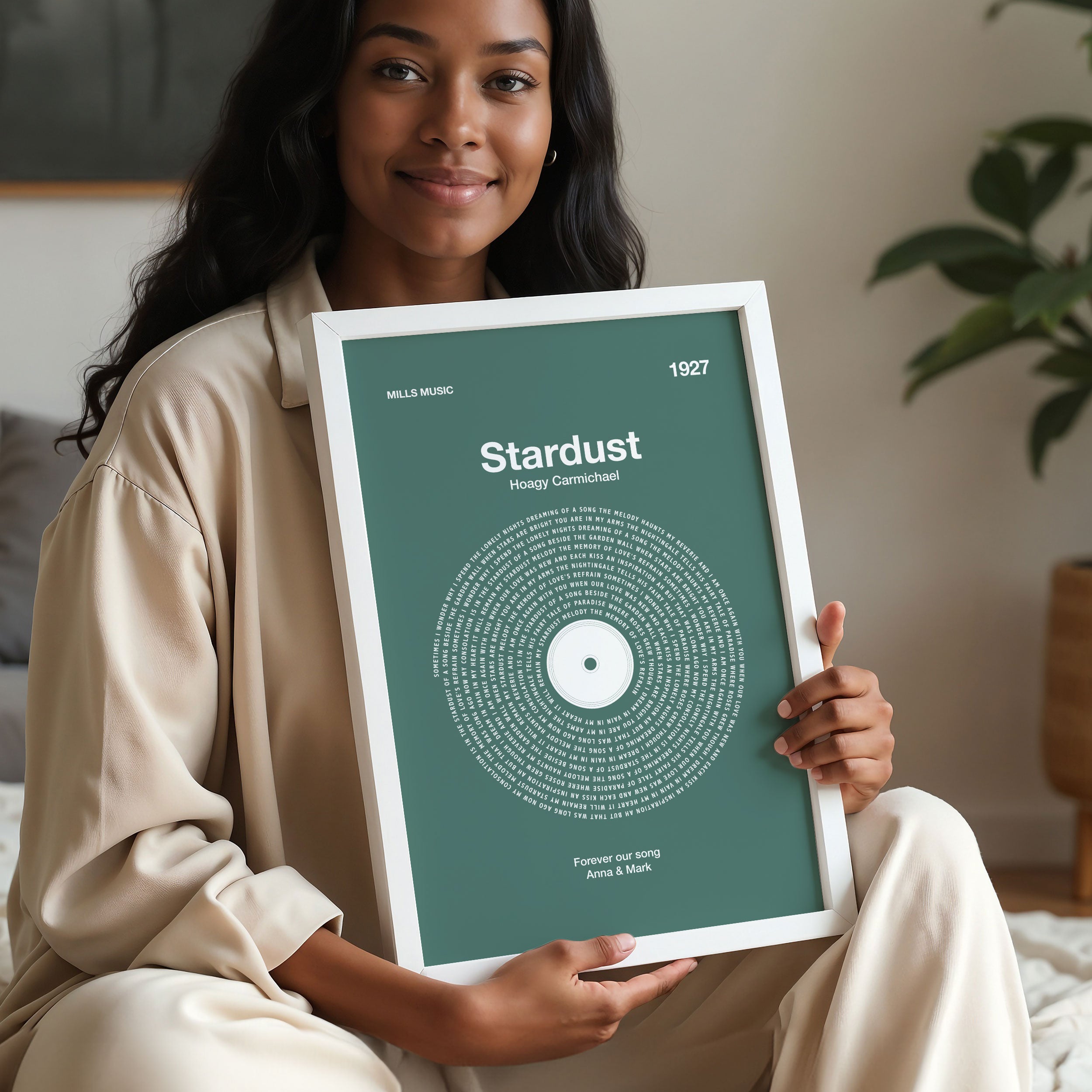 Soothing Sage Green background custom vinyl lyrics print, tranquil song wall art decor. Woman holding a framed artwork with 'Stardust' design