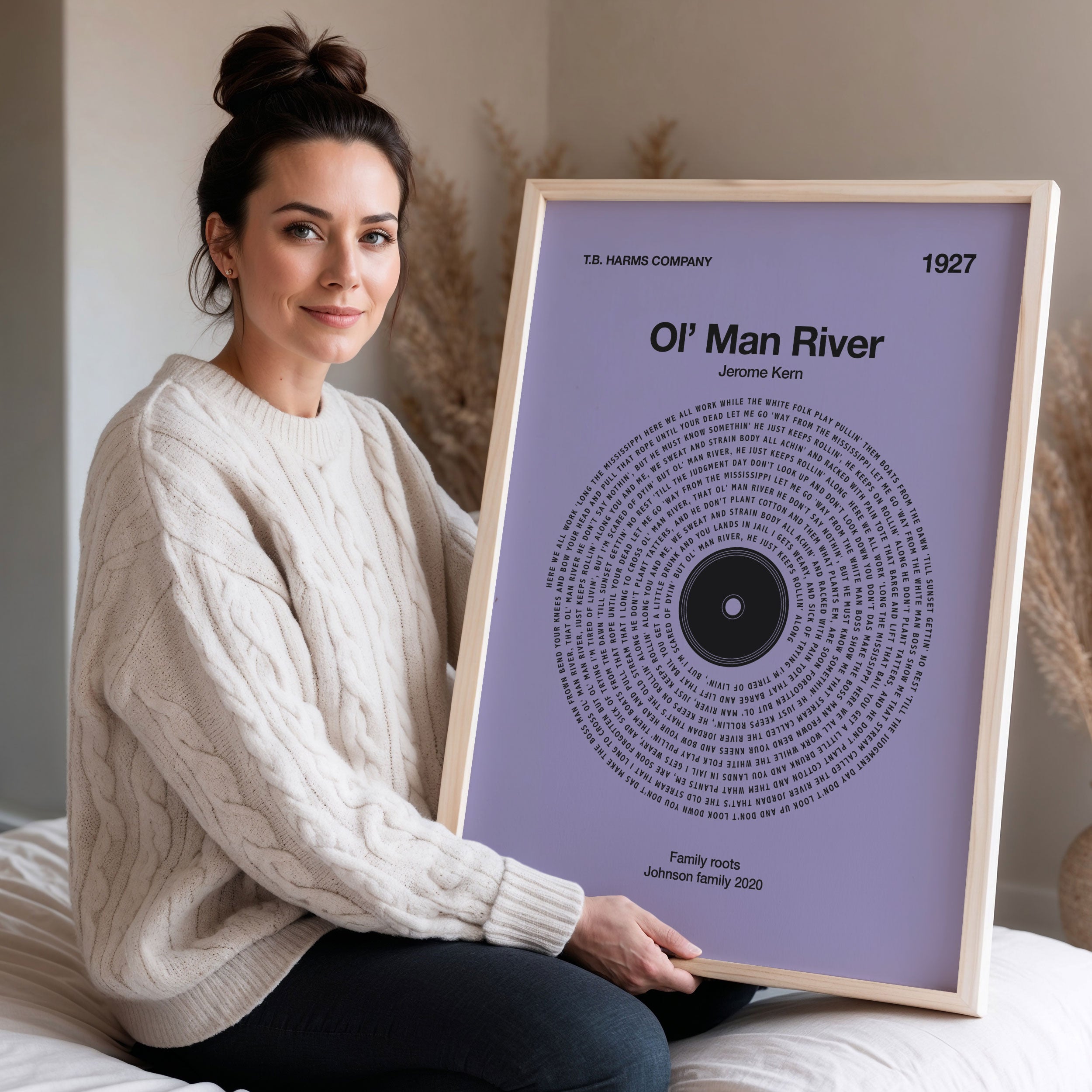 Mauve background custom vinyl record style print. Woman holding a framed print of 'Ol' Man River' by Jerome Kern