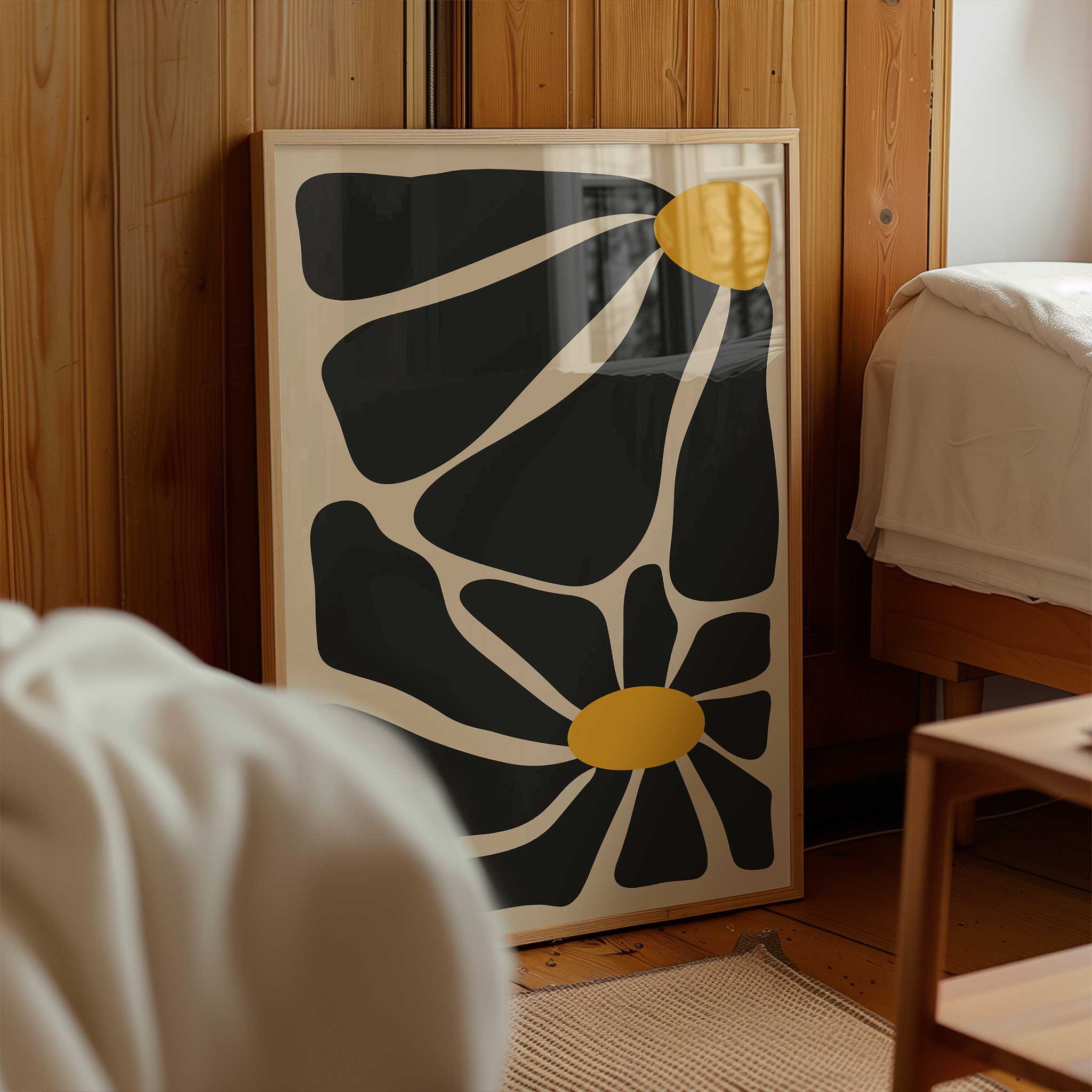 A bold, contemporary abstract print of two flowers with oversized black petals and vivid golden centers.