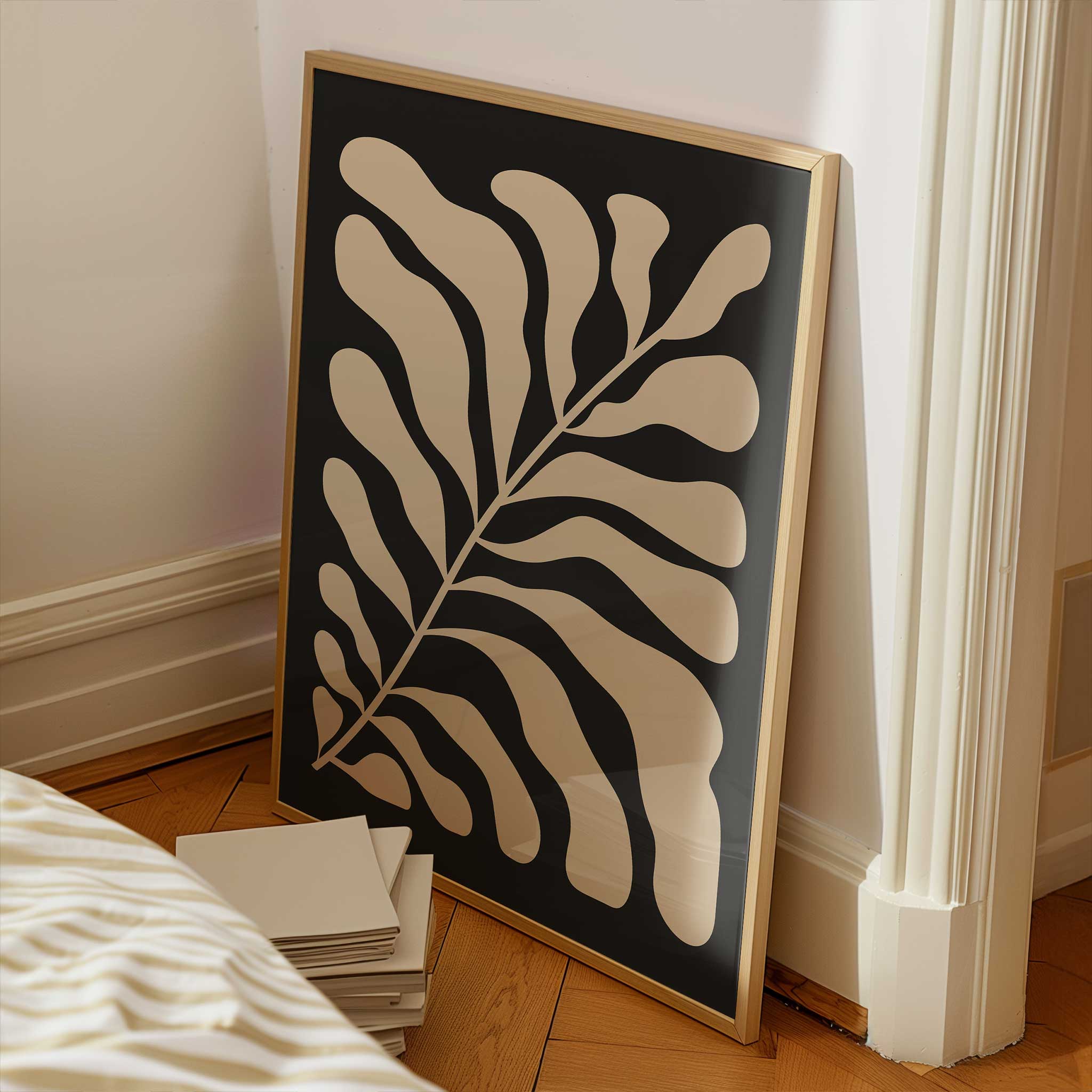 A minimalist print of flowing beige botanical leaves against a solid black background.