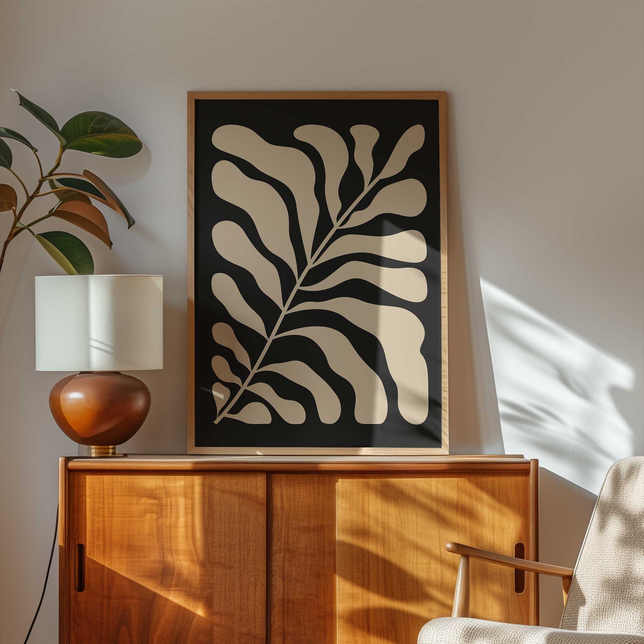 A minimalist print of flowing beige botanical leaves against a solid black background.