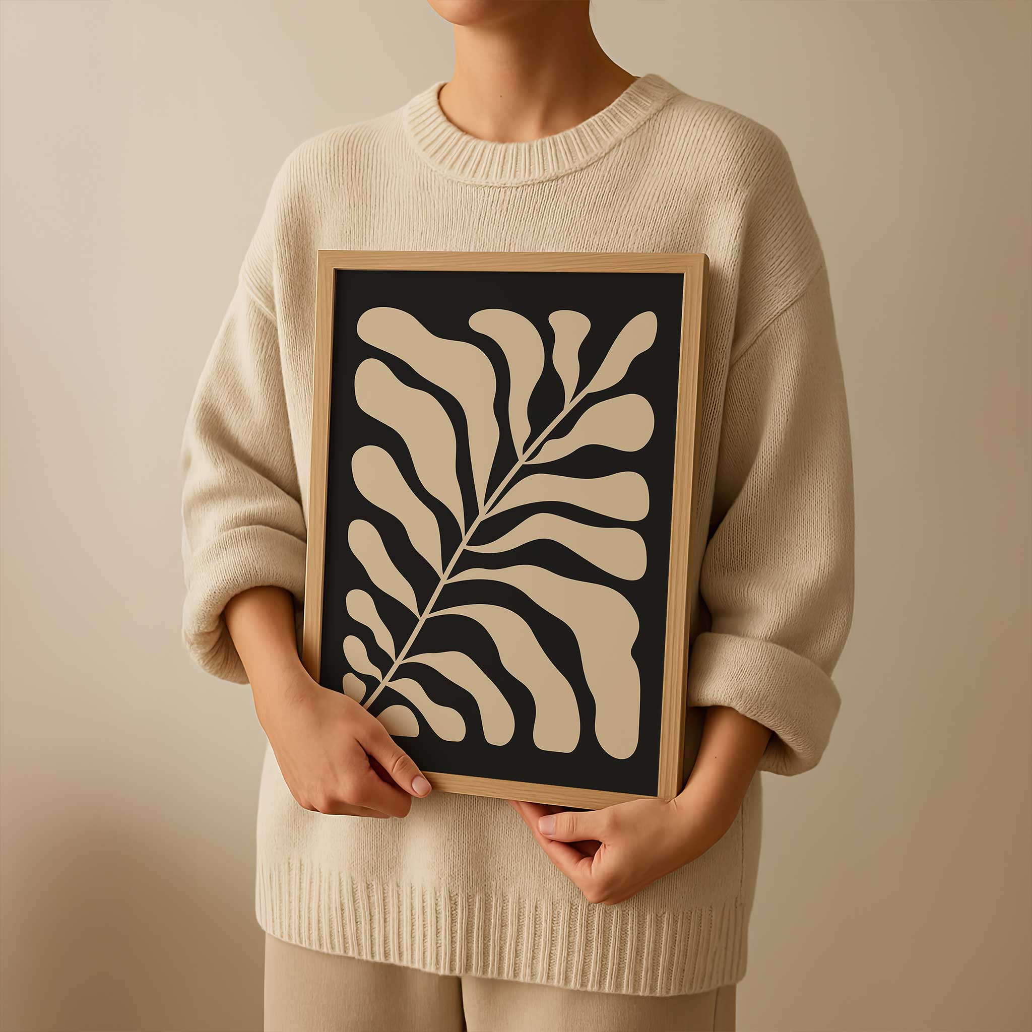 A minimalist print of flowing beige botanical leaves against a solid black background.