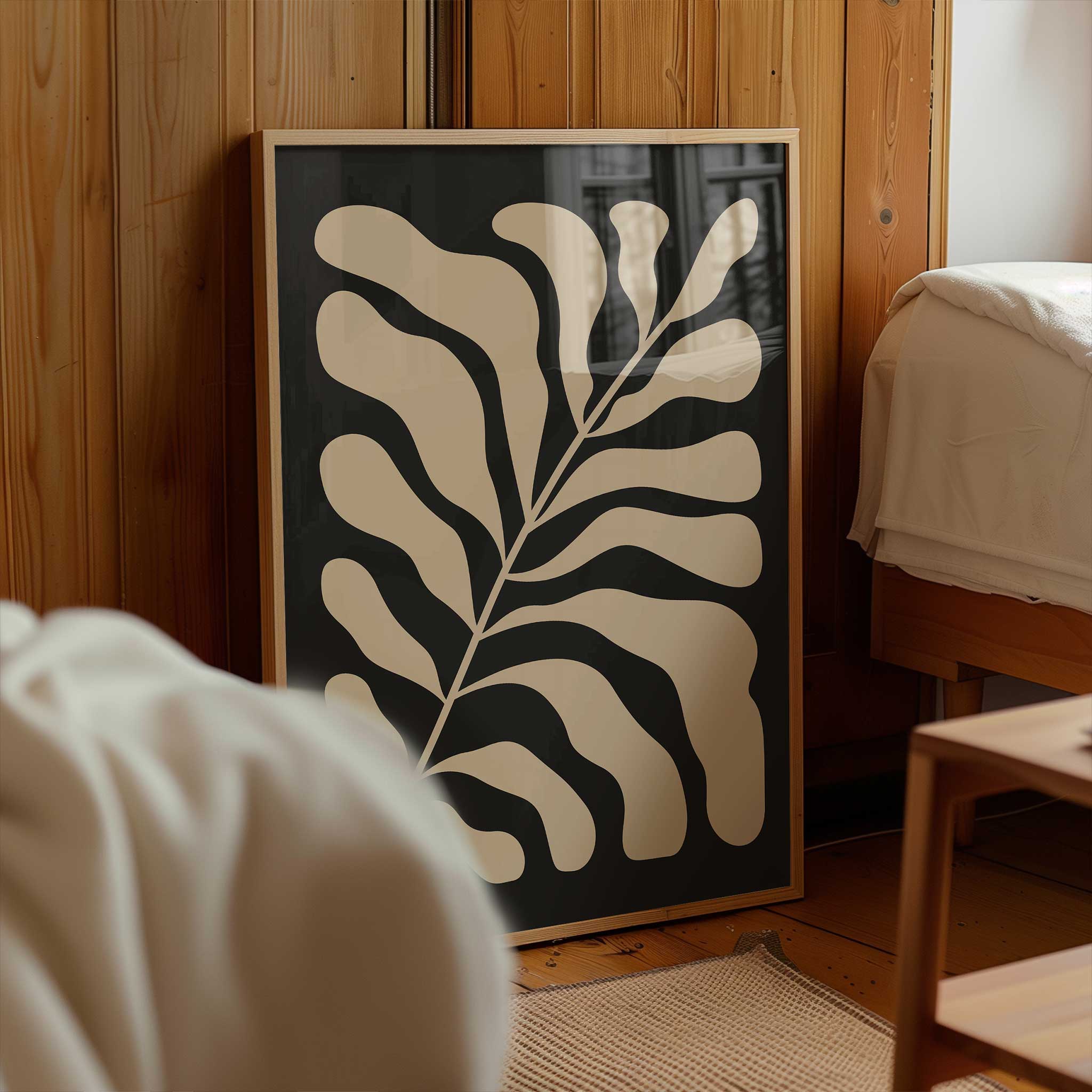 A minimalist print of flowing beige botanical leaves against a solid black background.