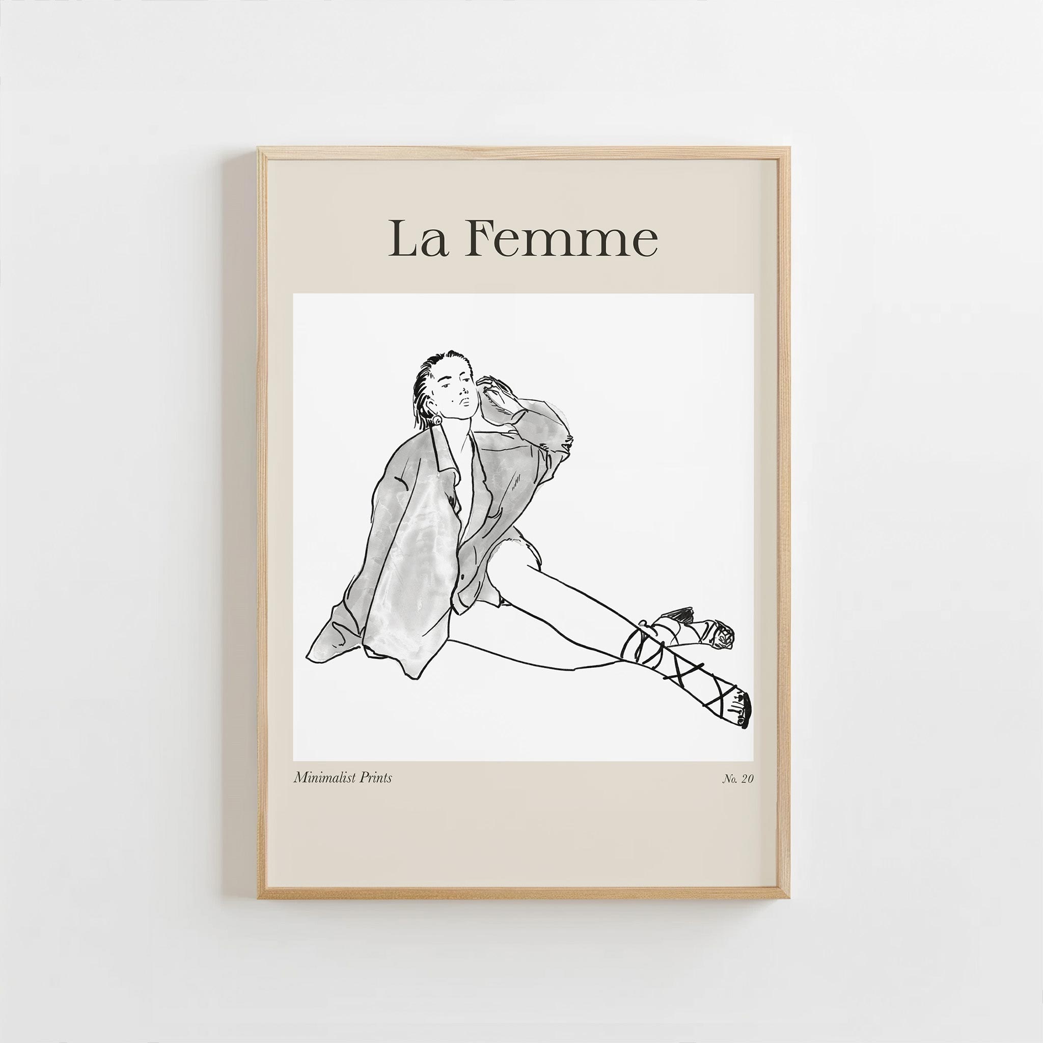 Framed artwork of a line drawing of a woman sitting with 'La Femme' text on a beige background