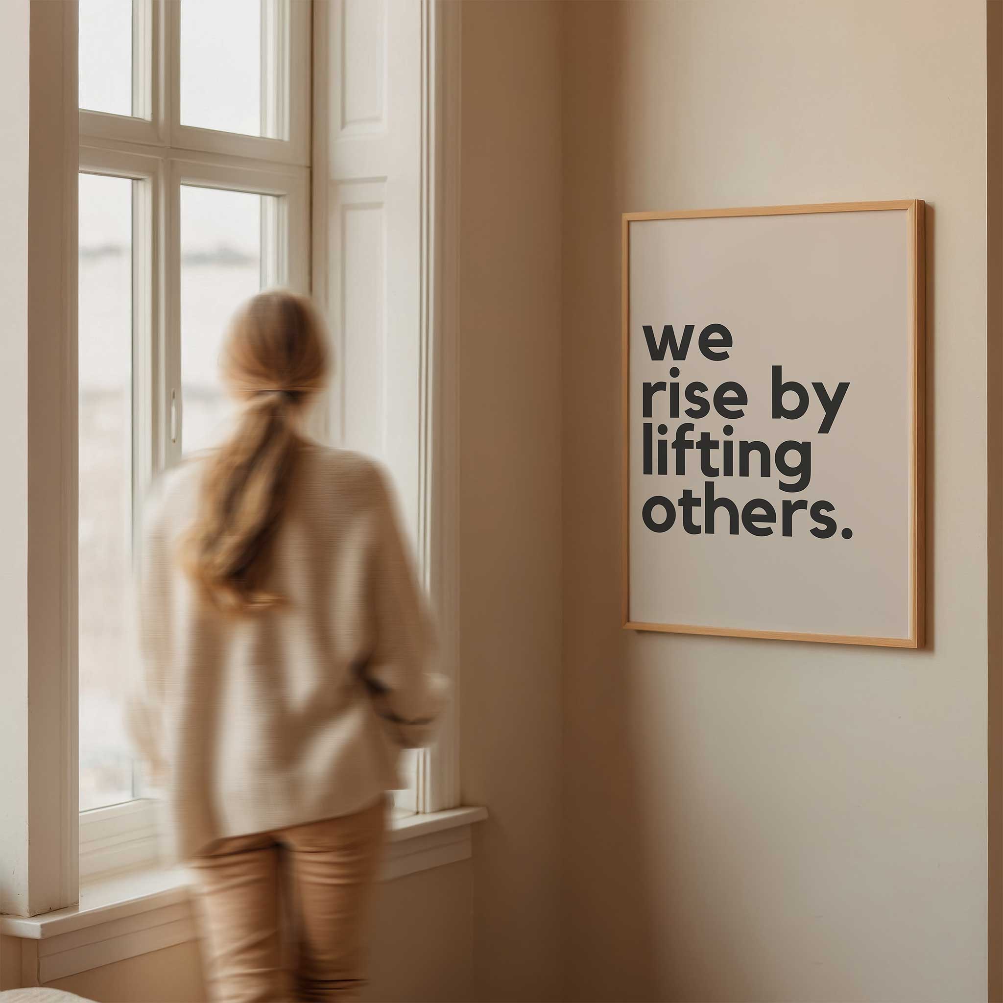 We Rise by Lifting Others' empowering typography, framed wall art print for a kindness aesthetic, titled 'We Rise by Lifting Others'